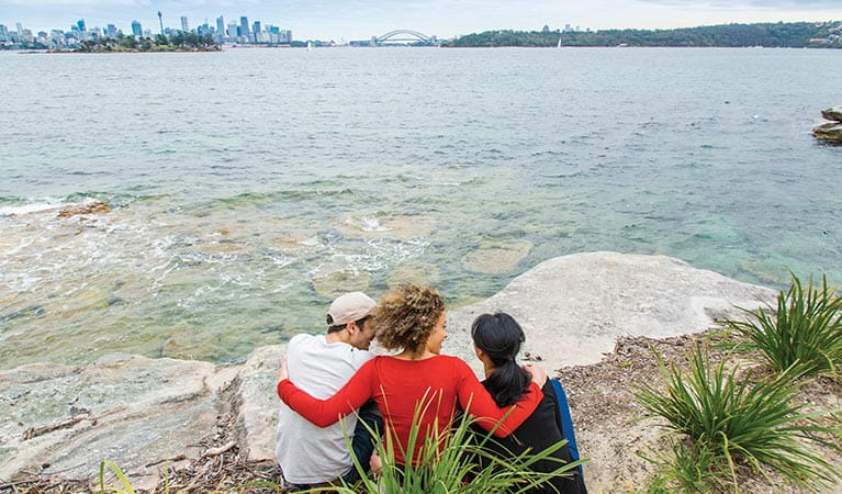 Friends admiring the view of the Sydney Harbour skyline from Hermitage Foreshore track. Photo: Simone Cottrell/DPIE