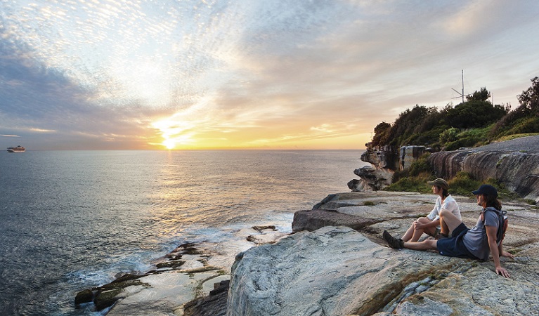 A couple enjoying the sunrise, Hornby Lighthouse at South Head, Sydney Harbour National Park. Photo: David Finnegan &copy; DPIE