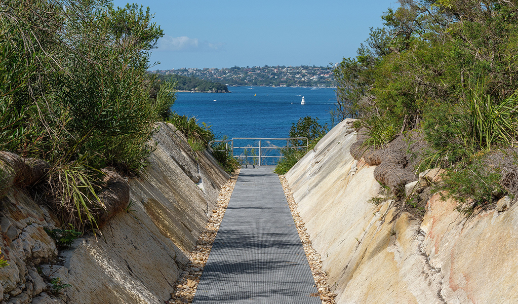 A defensive ditch with the harbour in the background at Middle Head in Sydney Harbour National Park. Photo: Simon Wood &copy; DCCEEW