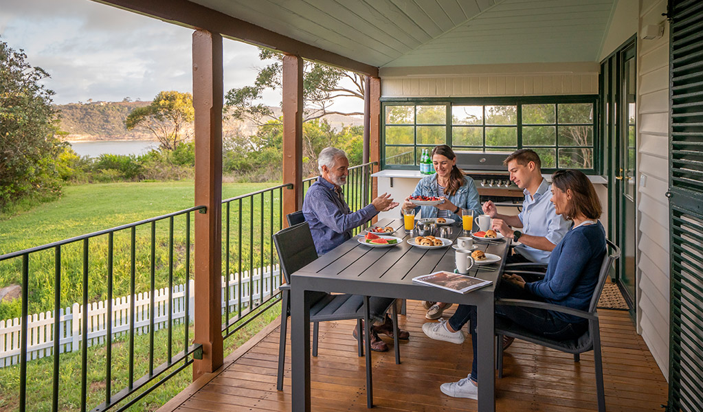 Guests eating on the balcony at Middle Head Officers Quarters. Credit: John Spencer &copy; DCCEEW