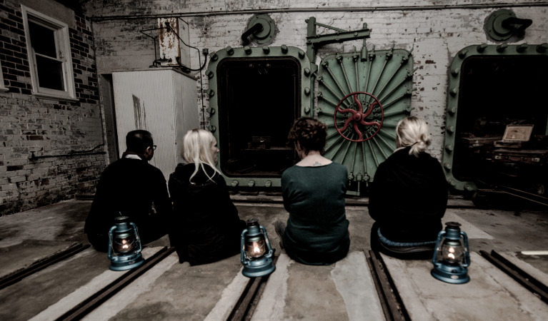 4 people with lanterns on a ghost tour of Q Station. Photo: Q Station