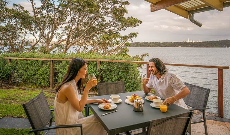 Guests eating breakfast in the outdoor seating area at Steele Point Cottage. Photo: John Spencer/OEH