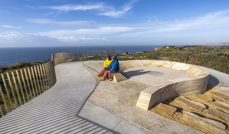 Visitors take a moment on the sandstone seats at Yiningma lookout, Sydney Harbour National Park. Photo: John Spencer &copy; DPE