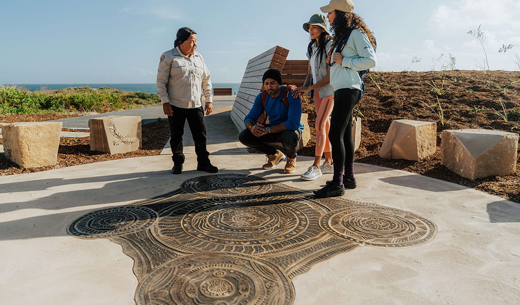 People admiring the cultural artwork by Worimi man, Gerard Black at Birubi Point Aboriginal Place. Credit: Remy Brand &copy; Remy Brand