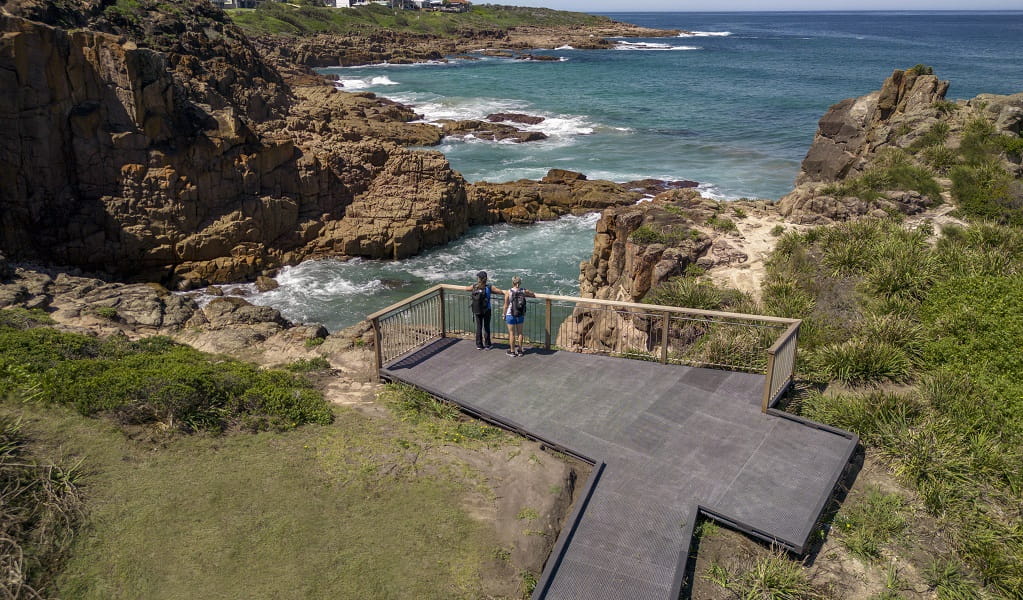 Two walkers take in ocean views from a lookout on the Tomaree Coastal walk, near Iris Moore lookout and picnic area in Tomaree National Park. Photo: John Spencer &copy; DPE