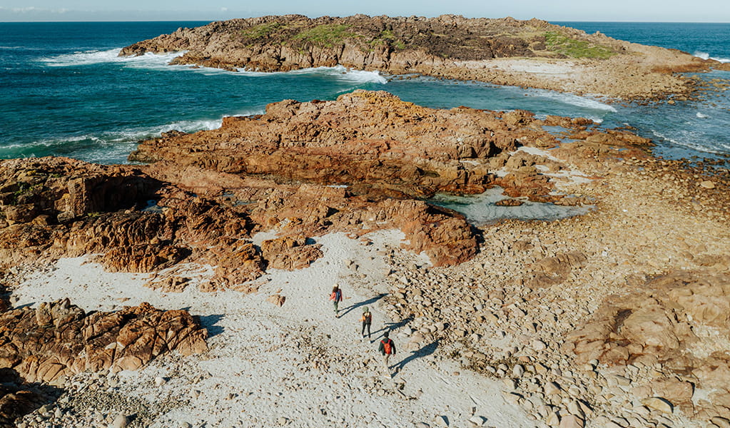Aerial photo of walkers approaching the coastal rock formations and rockpools at a spot named Big Rocky. Credit: Daniel Parsons &copy; Daniel Parsons