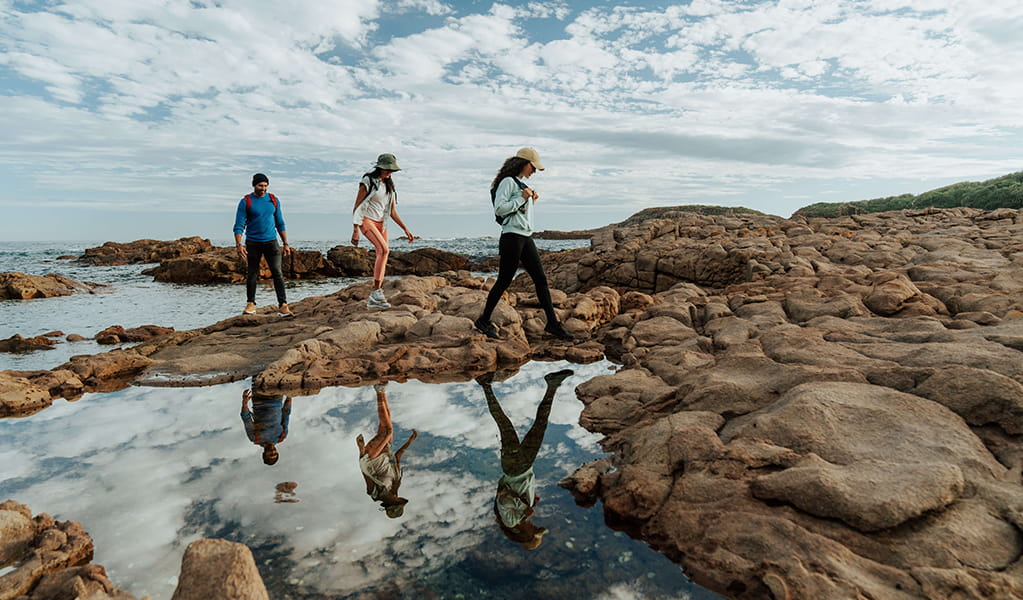 Walkers exploring a coastal rock platform along the Tomaree Coastal Walk. Credit: Remy Brand &copy; Remy Brand