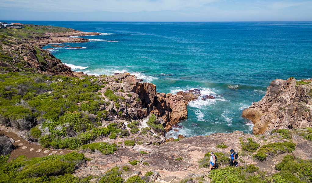 Aerial photo of walkers traversing coastal rock platforms before approaching stepping stones on Tomaree Coastal Walk. Credit: John Spencer &copy; DPE