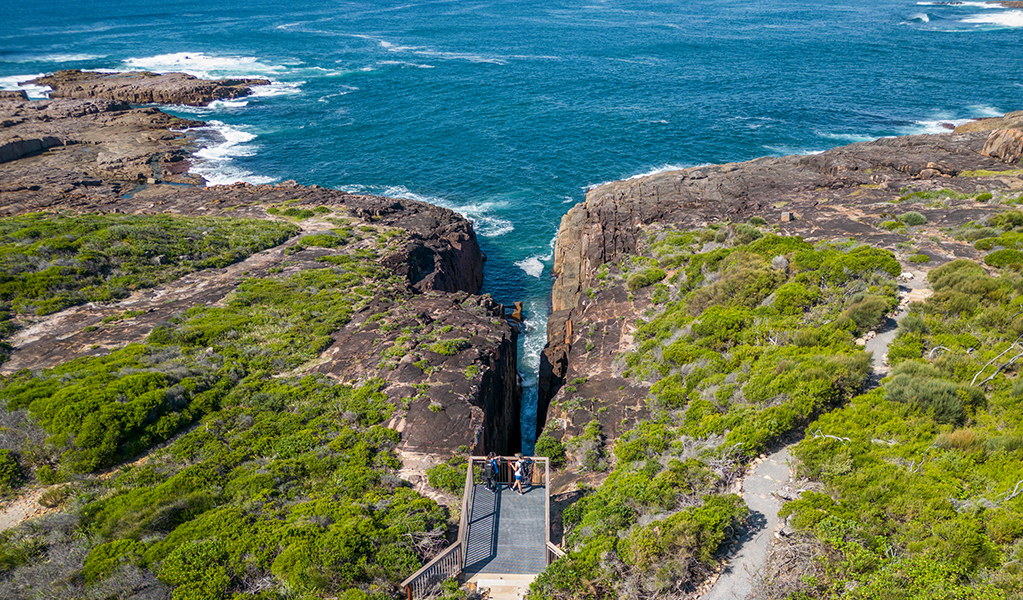Aerial photo of Slot canyon lookout, perched over the a gap in the cliffline above the ocean. Credit: John Spencer © DPE