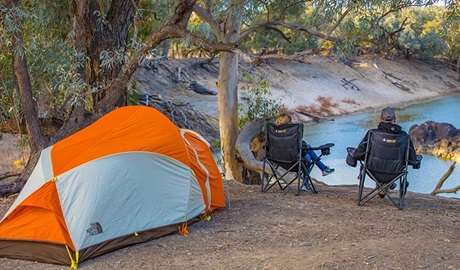 Campers sit next to a tent overlooking the river, Darling River campground, Toorale National Park. Photo: Joshua Smith/OEH.