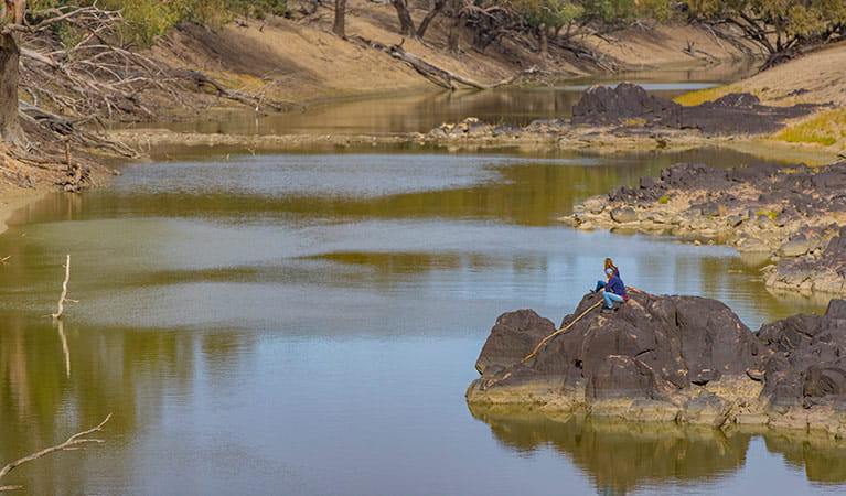 A couple sit on rocks beside the Darling River, Toorale National Park. Photo: Joshua Smith/OEH.