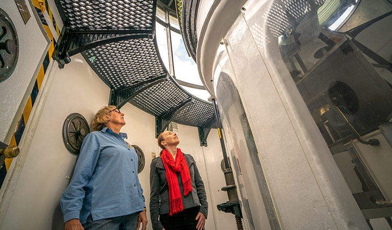 Two women in the tower of Cape Byron Lighthouse, Walgun Cape Byron State Conservation Area. Photo: John Spencer/DCCEEW.