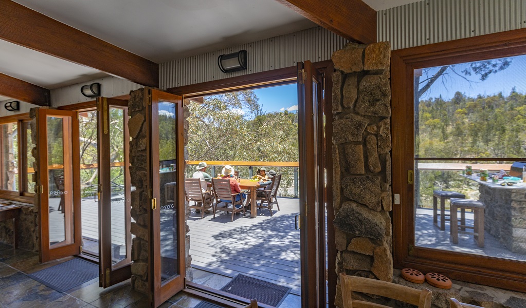 A family enjoys a meal on the sunny deck of Muluerindie, Warrabah National Park. Photo: Joshua Smith &copy; DPE