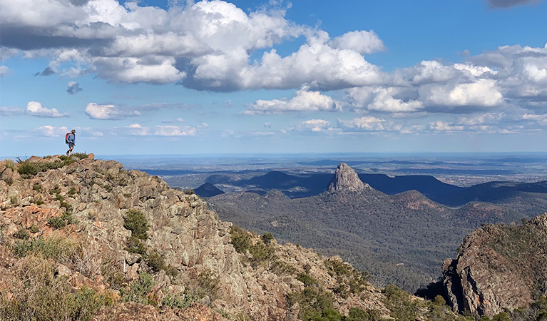 A hiker on Bluff Mountain's summit with mountainous landscape in the distance. Photo: Eveline Chan &copy; Eveline Chan