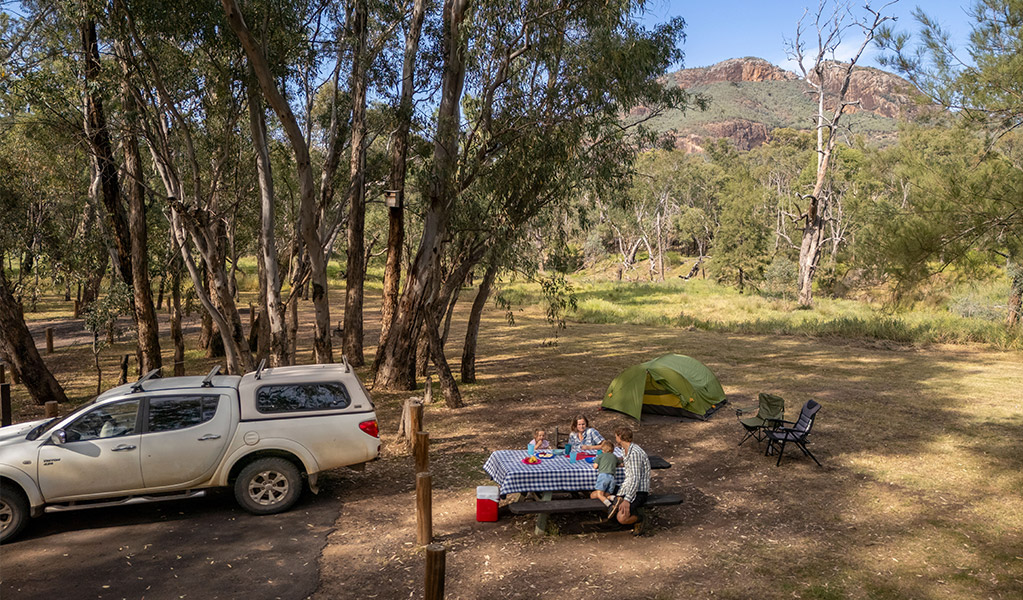 A family enjoying lunch at a picnic table, Camp Blackman. Credit: John Spencer &copy; DCCEEW