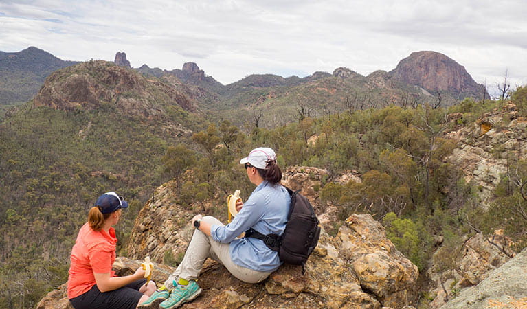 2 bushwalkers have a snack on Fans Horizon walking track in Warrumbungle National Park. Photo: Leah Pippos/OEH.