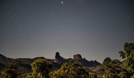 A starry night view across the Grand High Tops rock formation in Warrumbungle National Park. Photo: Robert Mulally/OEH