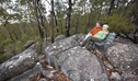 A couple dressed in warm clothes seated on a park bench atop a rock outcrop in a bushland setting. Photo credit: Rob Cleary &copy; DPIE