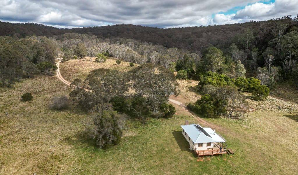 An aerial shot of Mooraback Cabin surrounded by World Heritage-listed Gondwana rainforest in Werrikimbe National Park. Photo: David Waugh &copy; DPE