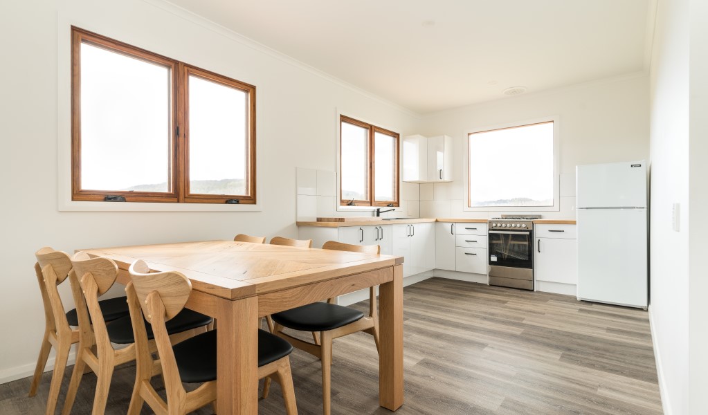 The dining table and kitchen in Mooraback Cabin, Werrikimbe National Park. Photo: David Waugh &copy; DPE