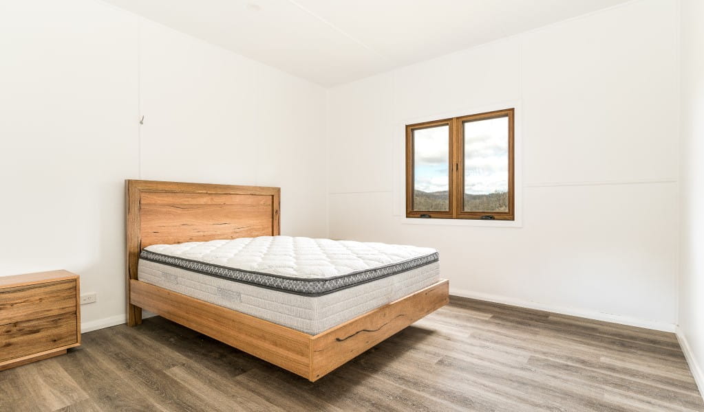 A bedroom with queen bed at Mooraback Cabin in Werrikimbe National Park. Photo: David Waugh &copy; DPE