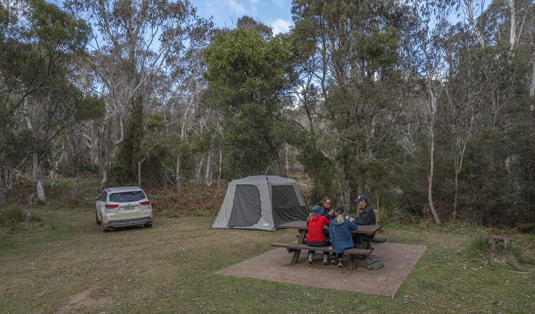 A family of campers enjoy a picnic by their tent, Werrikimbe National Park. Photo: Josh Smith &copy; DPE