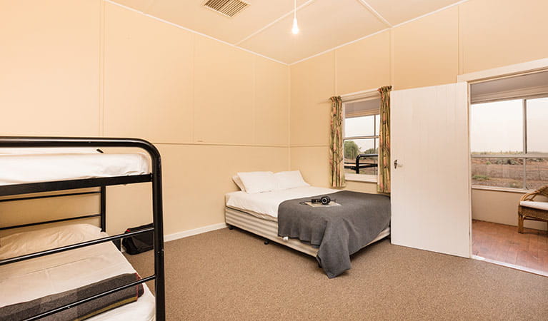 Queen bed and bunk bed in a bedroom at Willandra Cottage, Willandra National Park. Photo: Vision House Photography/DPIE