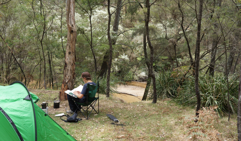 Camper relaxing by the river Newnes campground. Credit: Stephen Alton &copy; DPE