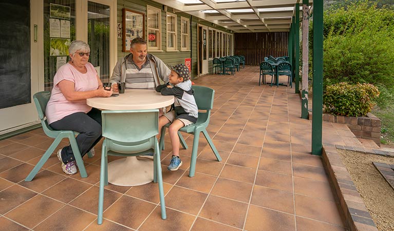 Family enjoying hot chocolates on the verandah of Kui Kiosk. Photo: OEH/John Spencer