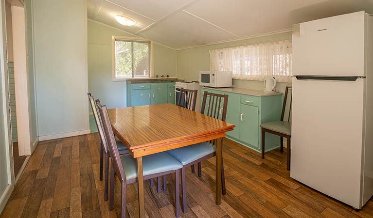 Kitchen of Post Office Cottage with dining table, fridge, oven and microwave. Photo: OEH/John Spencer