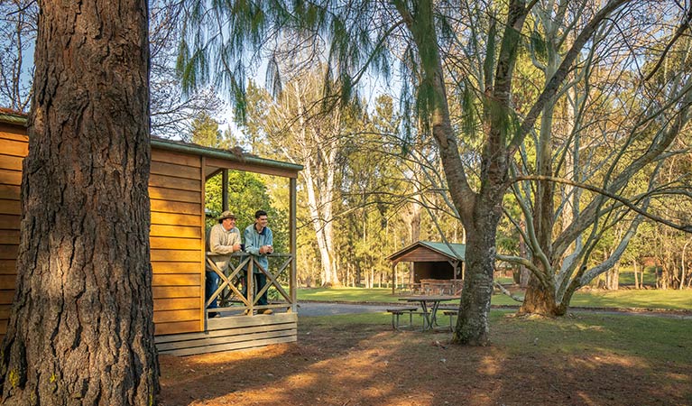 Friends on the balcony of a cabin at Wombeyan Caves. Photo: OEH/John Spencer