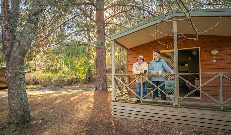 Father and son on balcony of one of the Wombeyan Caves cabins. Photo: OEH/John Spencer