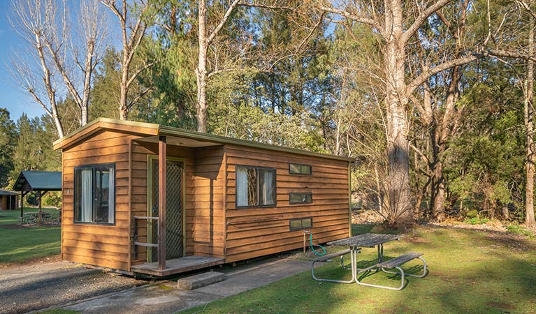 One of the smaller, standard cabins with a picnic table out the front. Photo: OEH/John Spencer