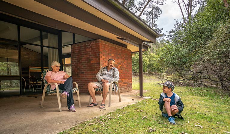 Family sitting outside Wombeyan Caves dormitories. Photo: OEH/John Spencer