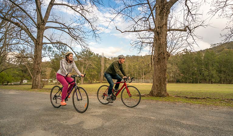 Father and daughter cycling on the road to the picnic area and Kui Kiosk. Photo: OEH/John Spencer