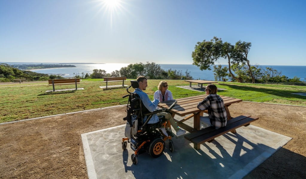 A group of friends at one of the accessible picnic tables at Crackneck Point lookout in Wyrrabalong National Park. Photo: John Spencer &copy; DPE
