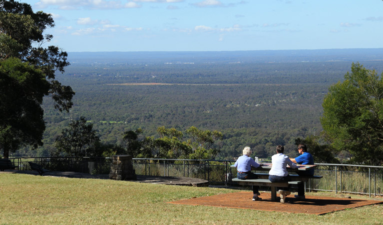 Three visitors sitting at the Hawkesbury lookout. Photo: John Yurasek