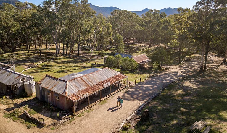 Two people walking from The Bank Room down the main street of Yerranderie Private Town, in Yerranderie Regional Park. Photo: John Spencer/OEH