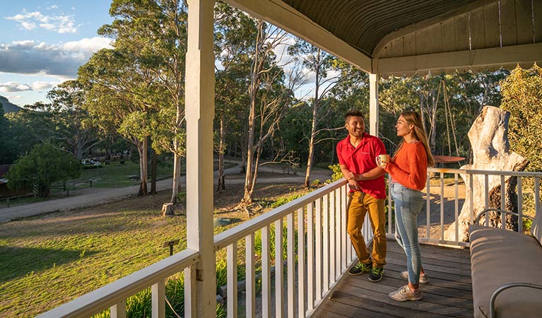 A couple looking out at Yerranderie Private Town from the balcony of Post Office Lodge in Yerranderie Regional Park. Photo: John Spencer/OEH