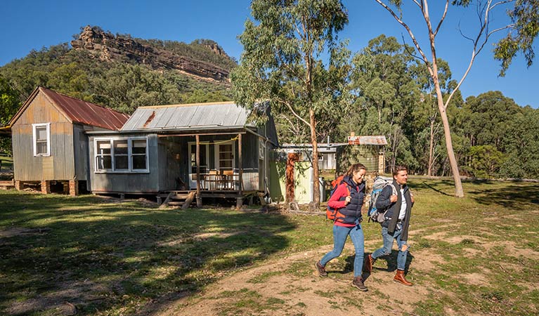 A couple hiking from Slippery Norris Cottage in Yerranderie Private Town, Yerranderie Regional Park. Photo: John Spencer/OEH