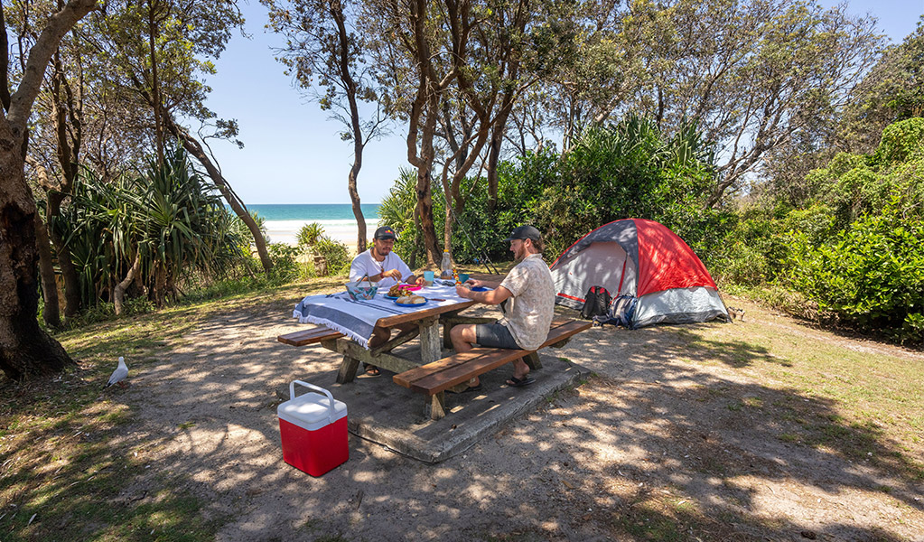 Campers enjoying lunch on the picnic bench on their campsite, Ilaroo campground. Credit: John Spencer &copy; DCCEEW