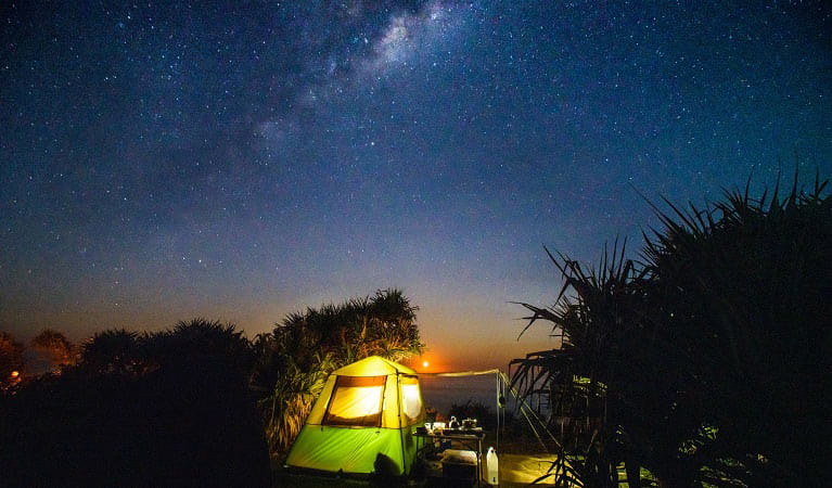 Tent lit up at night with view of the stars above. Photo: Jessica Robertson