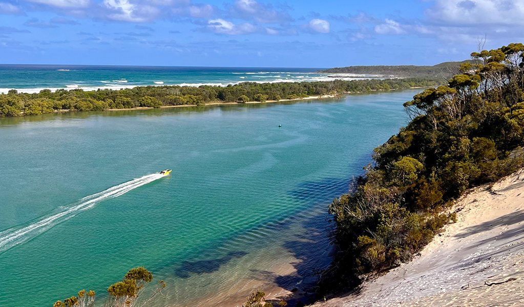 A speedboat motors up the Wooli Wooli River, which is separated from the Pacific Ocean by the Wooli Peninsula (two waters), Yuraygir coastal walk, Yuraygir National Park. Photo: Peter Katelaris &copy; Peter Katelaris 