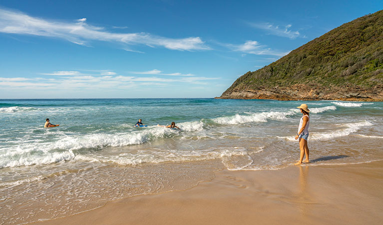 A mother watches her children swim in the ocean at Seven Mile Beach in Booti Booti National Park. Photo: John Spencer/DPIE