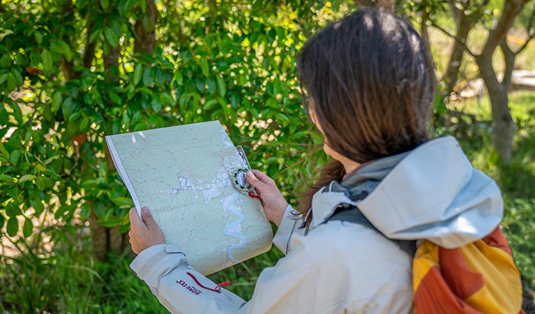 Bushwalker holding a compass and map. Photo: John Spencer/DPIE