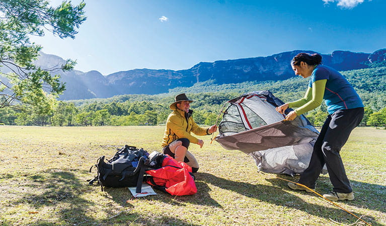 2 campers setting up a tent at Kedumba River Crossing campground. Photo: Simone Cottrell/DPIE