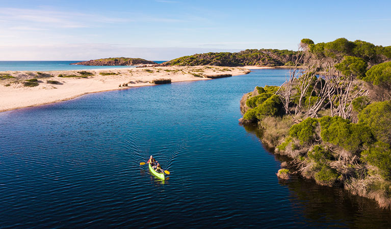 2 people in a canoe on Bournda Lagoon in Bournda National Park. Photo: Daniel Tran/DPIE