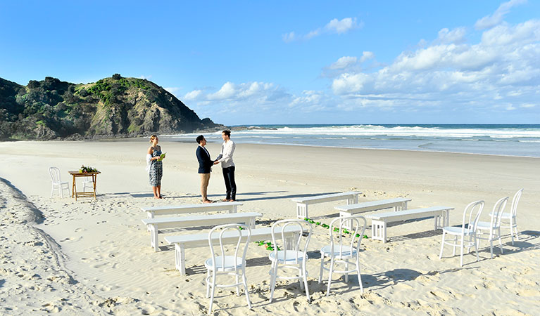 A couple saying their vows with the ocean in the background at Cosy Corner at Tallow Beach, Cape Byron State Conservation Area. Photo: Fiora Sacco &copy; DPIE