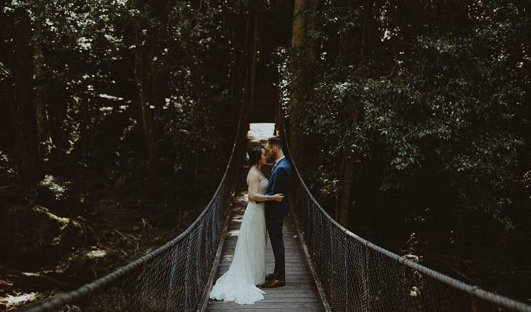 A bride and groom on the suspension bridge at Minnamurra Rainforest in Budderoo National Park. Photo &copy; Olguin Photography
