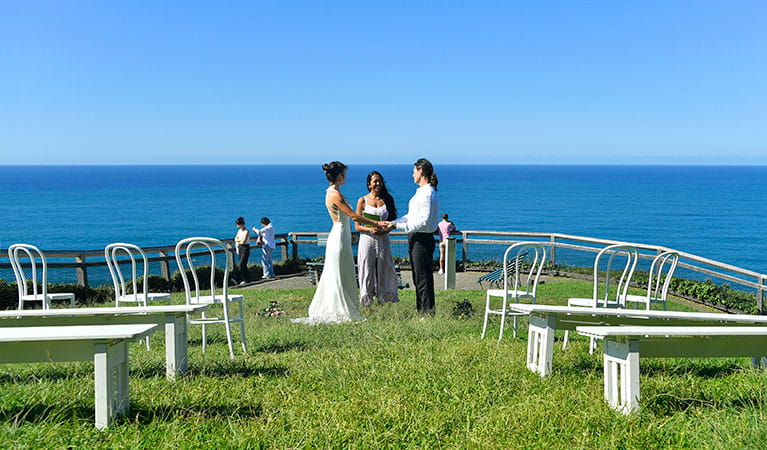 A couple saying their vows with the ocean in the background at Most Easterly Point in Cape Byron State Conservation Area. Photo: Fiora Sacco &copy; DPIE